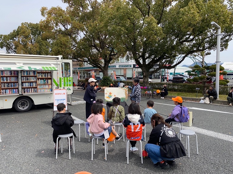 おはなし会の様子を写した写真。子どもたちが椅子に座って紙芝居を見ている