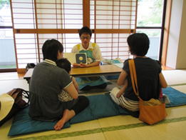 赤ちゃんと保護者に絵本の読み聞かせや説明を行っている写真